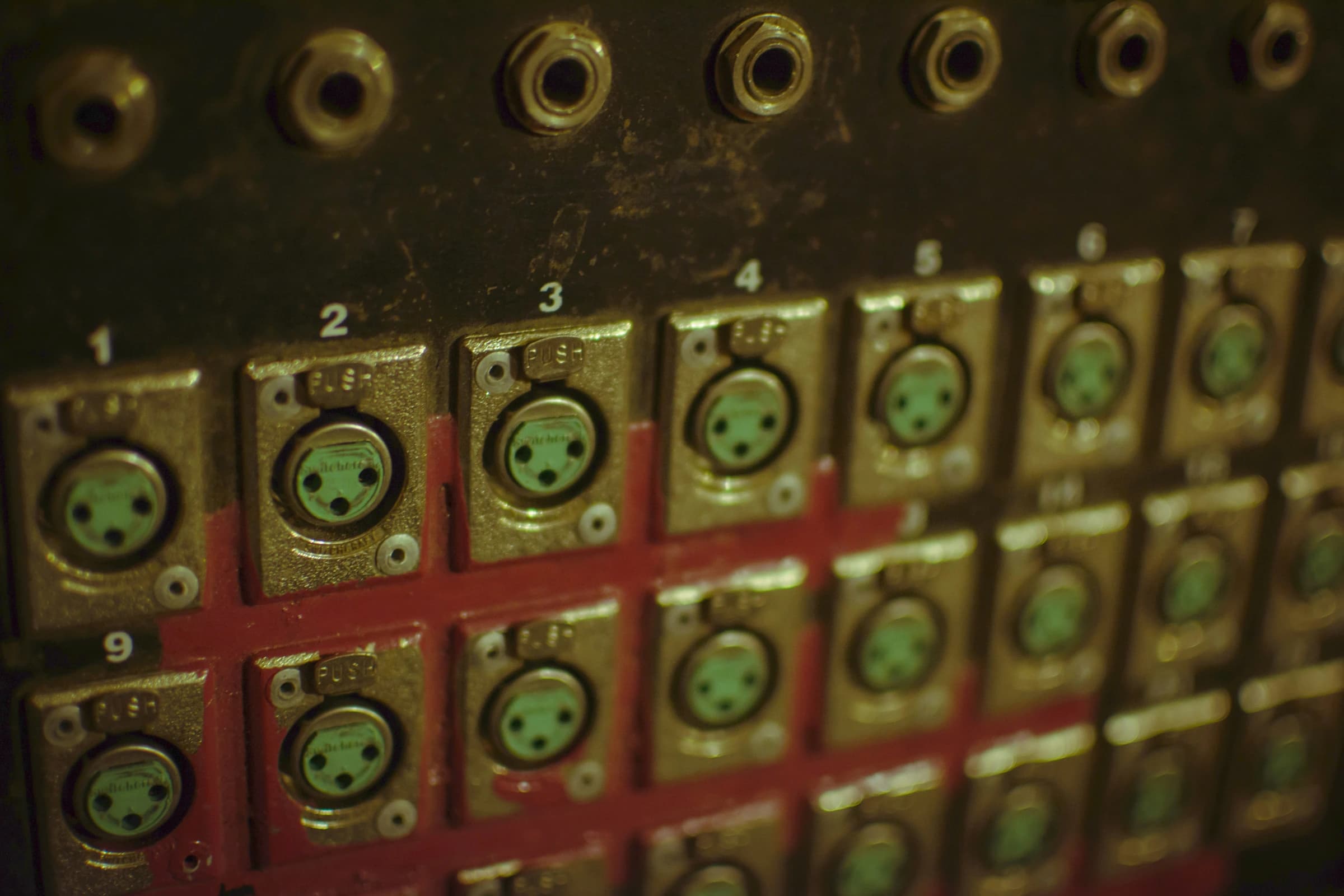 A red and black control panel with rows of numbered connector ports